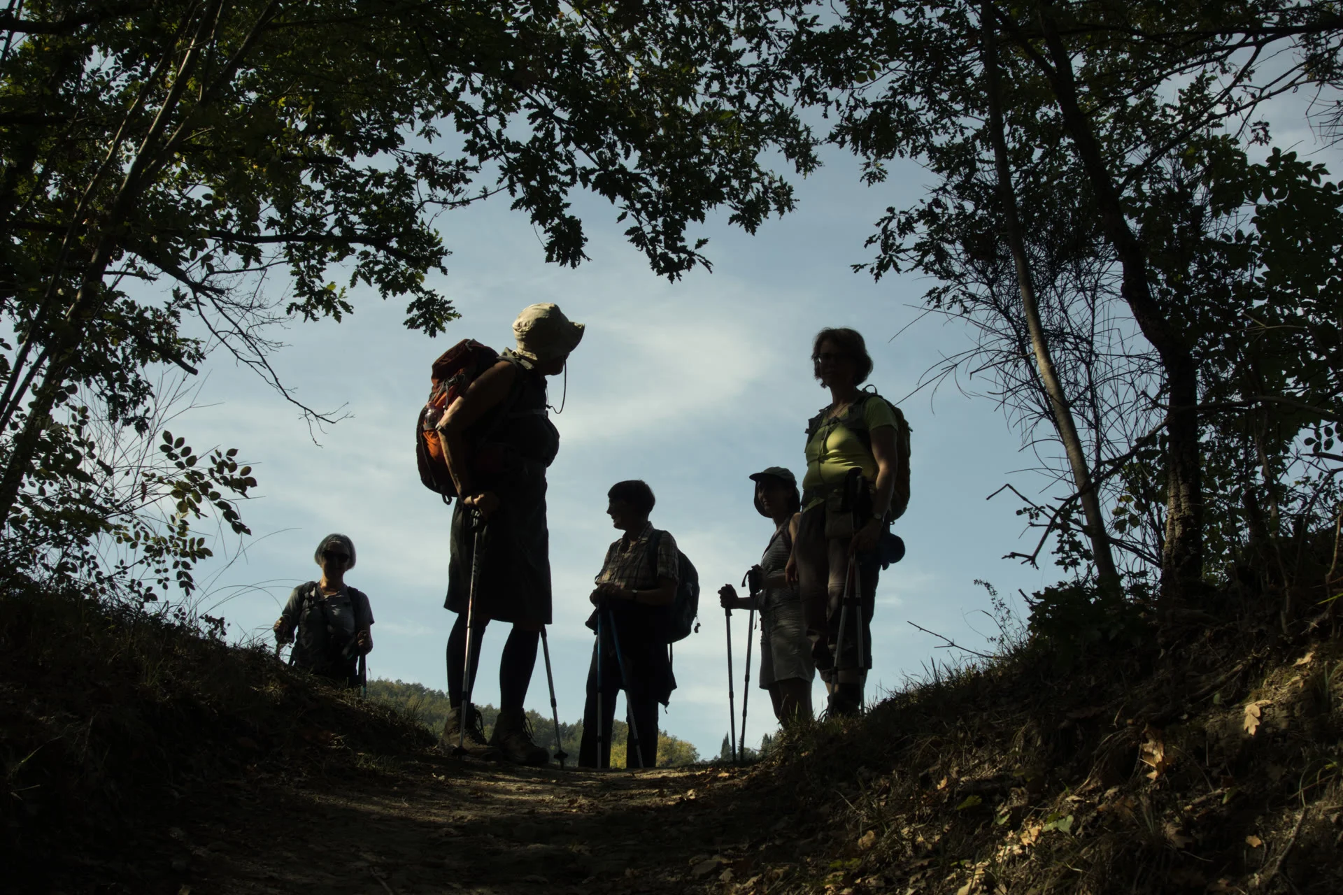 Gruppe von Pilgernden als Silhouetten auf einer Anhöhe